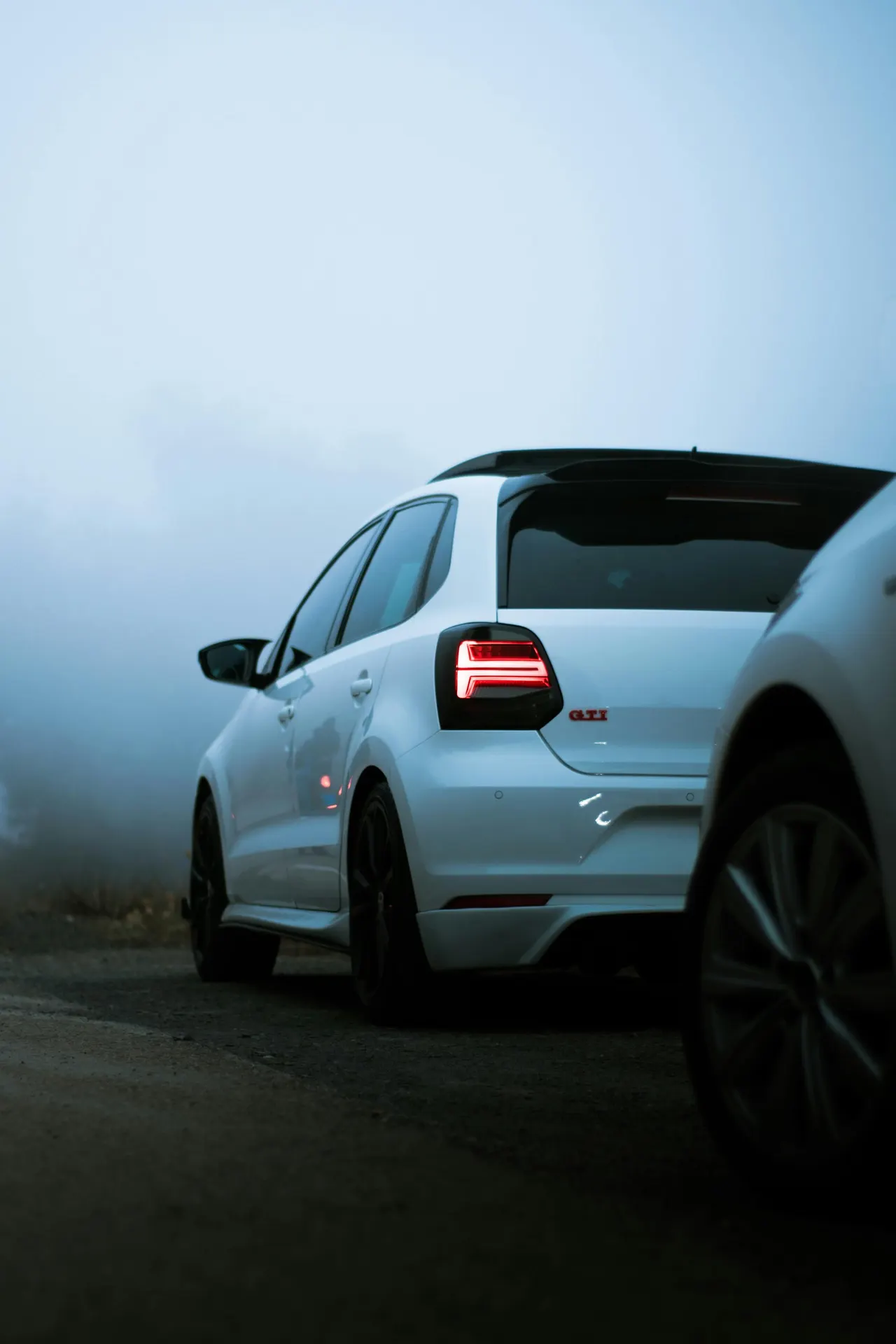 Volkswagen Polo GTI blanco, un compacto del Grupo Volkswagen, estacionado en una carretera con niebla